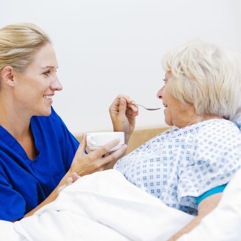 Nurse helping feed this patient